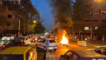 دراجة نارية تحترق في وسط تقاطع في طهران خلال احتجاجات على وفاة أميني (19 ايلول 2022، أ ف ب). 