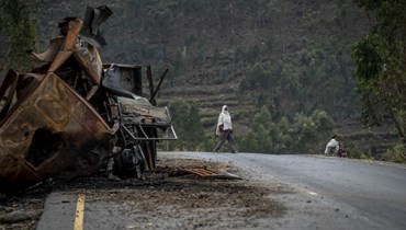 صورة ارشيفية- رجل يمر قرب شاحنة مدمرة على الطريق المؤدي إلى بلدة أبي عدي في منطقة تيغراي بشمال إثيوبيا (11 أيار 2021، أ ب). 