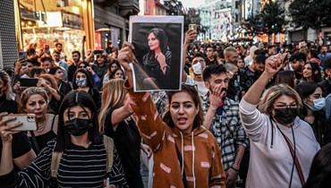 متظاهرة تحمل صورة مهسا أميني خلال مسيرة احتجاجية على وفاتها في شارع الاستقلال في اسطنبول (20 أيلول 2022، أ ف ب). 