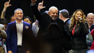 لولا دا سيلفا (في الوسط) وزوجته يشاركان في لقاء انتخابي في بورتو أليغري بالبرازيل (16 أيلول 2022، أ ف ب). 