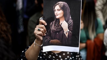 متظاهرة تحمل صورة مهسا أميني خلال مظاهرة أمام السفارة الإيرانية في بروكسيل (23 أيلول 2022 - أ ف ب).