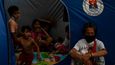 أشخاص يجلسون في خيام بمركز إجلاء في باسيكو بمانيلا بينما يقترب الإعصار نورو من الفيليبين (25 أيلول 2022ـ أ ف ب). 