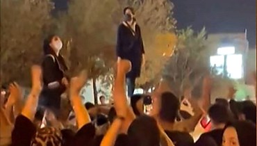 لقطة شاشة من فيديو من تظهر نساء إيرانيات يتظاهرن في شارع في وسط مدينة يزد في 26 أيلول 2022، احتجاجا على وفاة أميني (أ ف ب). 