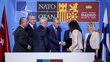 إردوغان (في الوسط) مصافحا وزيرة الخارجية السويدية آن ليند بعد توقيع مذكرة وافقت فيها تركيا على عضوية فنلندا والسويد في الناتو، خلال لقاء في مدريد بإسبانيا (28 حزيران 2022، أ ب). 
