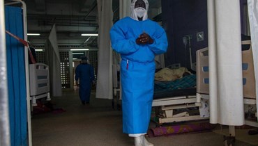 عضو من الطاقم الطبي الأوغندي لوحدة علاج الإيبولا يقف داخل الجناح في معدات الحماية الشخصية(أ ف ب)