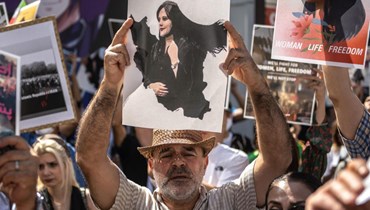 متظاهرون يحملون صورة مهسا أميني في أول تشرين الأول (أ ف ب).