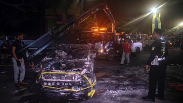 رافعة تستعد لرفع سيارة محترقة خارج استاد كانجوروهان في مالانغ بجاوة الشرقية (2 ت1 2022، أ ف ب). 