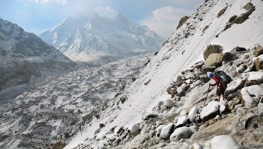 صورة ارشيفية- مرشد سياحي يتنقل بين صخور جليدية وهو ينزل من سلسلة تلال جبلية في ولاية أوتارانتشال شمال الهند (أيار 2019- أ ب).