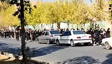 لقطة شاشة من فيديو تم توفيره على منصة ESN في 4 تشرين الاول 2022، وتُظهر طلاب مدارس يهتفون لدى خروجهم في شوارع مدينة سقز بمحافظة كردستان الإيرانية، مسقط رأس مهسا أميني (أ ف ب).
