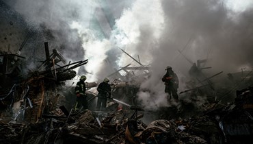 رجال إطفاء أوكرانيون يخمدون حريقًا بعد غارة في زابوريجيا (6 ت1 2022، أ ف ب).