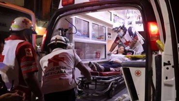 عناصر الإسعاف ينقلون أحد الطلاب في المكسيك إلى المستشفى.