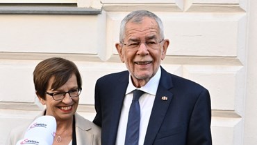 فان دير بيلين وزوجته دوريس يتحدثان إلى وسائل الإعلام أمام مركز اقتراع في فيينا (9 ت1 2022، أ ف ب). 
