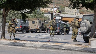 عناصر من قوات الأمن الإسرائيلية انتشروا في منطقة دير شرف  قرب مستوطنة شافي شومرون الإسرائيلية، غرب نابلس بالضفة الغربية المحتلة (11 ت1 2022، أ ف ب). 