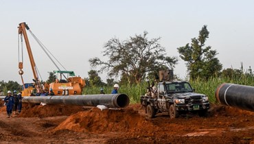 عمال من النيجر والصين في موقع بناء خط أنابيب النفط في منطقة غايا بالنيجر (10 ت1 2022، أ ف ب).