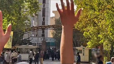 لقطة شاشة من فيديو تظهر طلابا ايرانيين في جامعة طهران وهم يصرخون على قوات الأمن الإيرانية التي تجمعت خارج بوابة الحرم الجامعي (13 ت1 2022، أ ف ب).