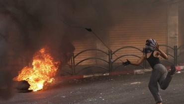 متظاهر فلسطيني خلال مواجهات في وسط مدينة الخليل بالضفة الغربية المحتلة (أ ف ب). 