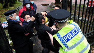 مشاجرة بين متظاهر من هونغ كونغ مؤيد للديموقراطية (في الوسط) وموظفين في القنصلية الصينية، خلال تظاهرة خارج القنصلية في مانشستر، حيث يحاول شرطي بريطاني التدخل (16 ت1 2022، أ ف ب). 