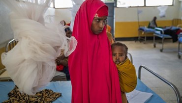 امرأة تحمل طفلًا في عيادة في دولو بالصومال (21 أيلول 2022، أ ف ب). 