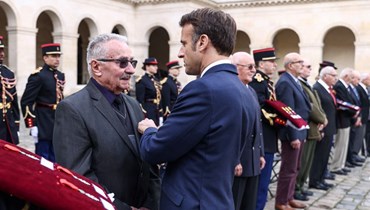 ماكرون (الى اليمين) يمنح أوسمة قدامى المحاربين الذين قاتلوا في حرب الجزائر خلال تكريمهم في باريس (18 ت1 2022، أ ف ب). 