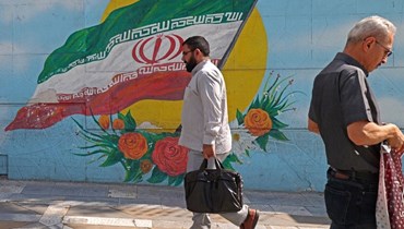 رجل يمر قرب جدارية في طهران (11 ت1 2022، أ ف ب). 