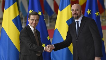 رئيس الوزراء السويدي أولف كريسترسون (إلى اليسار) يصافح رئيس المجلس الأوروبي شارل ميشال لدى وصوله لحضور قمة قادة الاتحاد الأوروبي في بروكسيل (20 ت1 2022، أ ف ب). 