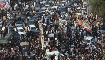 خان (في الوسط) خلال مسيرة مناهضة للحكومة في لاهور باتجاه إسلام أباد (28 ت1 2022، أ ف ب). 
