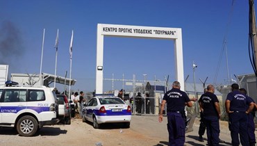 عناصر من قوات الأمن القبرصية انتشروا عند مدخل مخيم بورنارا (28 ت1 2022، أ ف ب). 