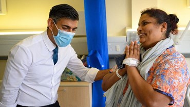 سوناك يتحدث الى المريضة سريجا غوبالان خلال زيارته مستشفى كرويدون جنوب لندن (28 ت1 2022، أ ف ب).  