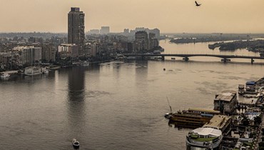 طائر يحلق فوق نهر النيل بين القاهرة (الى اليسار) ومدينتها التوأم الجيزة (الى اليمين) (1 ت2 2022، أ ف ب). 
