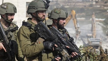 عناصر من الجيش الإسرائيلي قرب مبنى دمرته جرافات الجيش في مدينة الخليل الفلسطينية (31 ت1 2022 - أ ف ب).