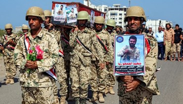 مقاتلون موالون للحكومة اليمنية يمشون خلال تشييع جماعي لاترابهم الذين قتلوا خلال اشتباكات مع الحوثيين، في محافظة الحديدة غرب اليمن (31 ت1 2022، أ ف ب). 