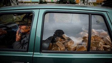  متطوّع يدخّن سيجارة أثناء نقل الخبز إلى قرية قريبة بسيارته في بلدة باخموت الواقعة في منطقة دونيتسك في شرق أوكرانيا (أ ف ب).