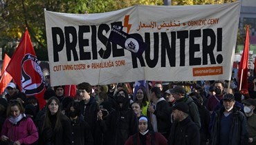 متظاهرون يحملون لافتة كُتب عليها "تنخفض الأسعار!" خلال مظاهرة بعنوان إعادة التوزيع في برلين (أ ف ب). 