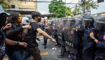 متظاهرون مؤيدون للديمقراطية يواجهون شرطة مكافحة الشغب في بانكوك (18 ت2 2022، أ ف ب). 