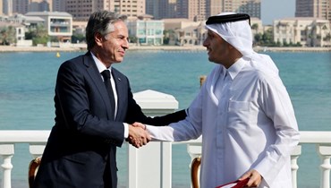 مصافحة بين بلينكن (إلى اليسار) ونظيره القطري محمد بن عبد الرحمن آل ثاني خلال احتفال توقيع وثيقة عقب اجتماعهما في الدوحة (22 ت2 2022، أ ف ب). 