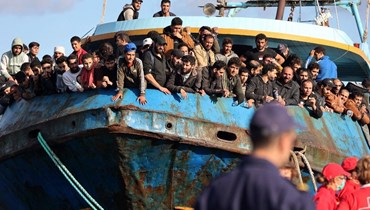 لاجئون ومهاجرون تم إنقاذهم يقفون على متن قارب في بلدة باليوتشورا جنوب غرب جزيرة كريت بعد عملية إنقاذ (22 ت2 2022، أ ف ب). 