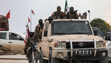 مقاتلون سوريون في قافلة خلال مناورة عسكرية لفرقة "سليمان شاه" المدعومة من تركيا في منطقة عفرين شمال سوريا (22 ت2 2022، أ ف ب). 