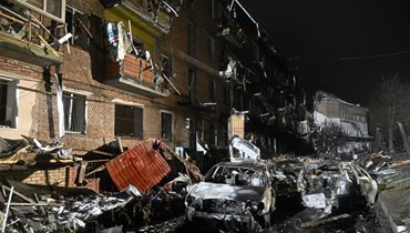 سيارات محترقة أمام مبنى سكني مدمر بعد غارة روسية على بلدة فيشجورود في ضواحي كييف (23 ت2 2022، أ ف ب). 
