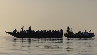 مهاجرون (إلى اليسار( ينقذهم متطوعون في سفينة اوشن فايكنيغ حوالى 26 ميلا بحريا جنوب جزيرة لامبيدوزا الإيطالية في البحر الأبيض المتوسط (27 آب 2022، أ ب).