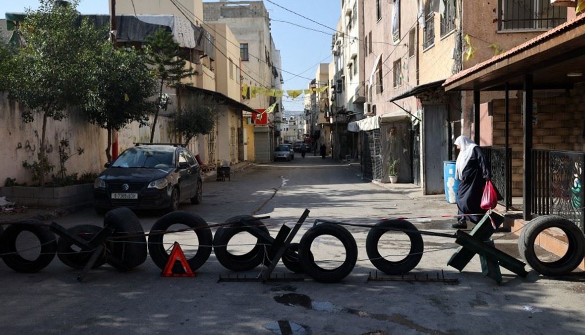 حاجز أقامه فلسطينيون لقطع شارع في حال تنفيذ الجيش الإسرائيلي مداهمة في مدينة جنين بالضفة الغربية المحتلة (23 ت2 2022، أ ف ب).