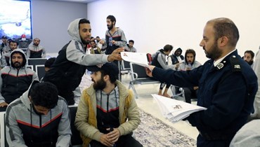 مهاجرون تجمعوا داخل مبنى وكالة مكافحة الهجرة غير الشرعية في  طرابلس، قبل ترحيلهم إلى بلدانهم الأصلية (24 ت2 2022، أ ف ب). 