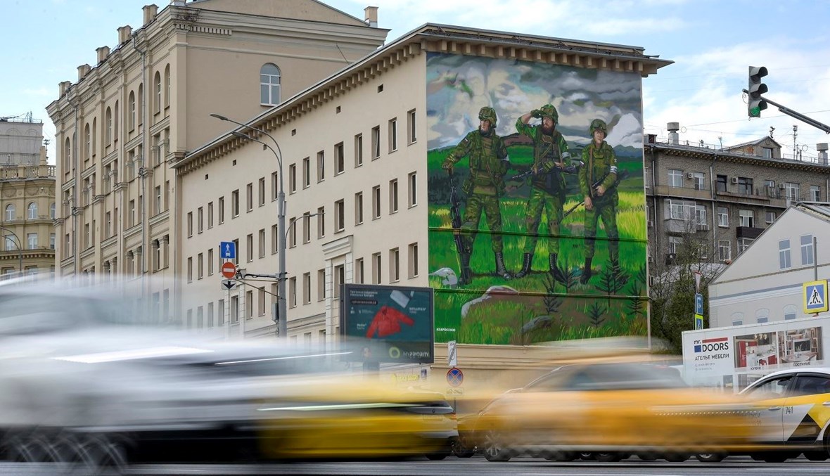 جدارية تصوّر ثلاثة جنود روس مسلّحين على مبنى في موسكو (12 ت1 2022 - أ ف ب).