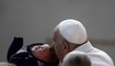البابا فرنسيس يقبل طفلا في نهاية اللقاء العام في ساحة القديس بطرس بالفاتيكان (23 ت2 2022، أ ف ب).