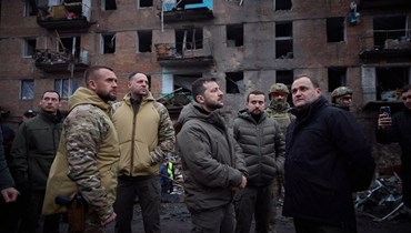 الرئيس الأوكراني فولوديمير زيلينسكي (في الوسط) يتفقد مبنى سكنيًا في فيشغورود تضرر في هجوم صاروخي روسي (أ ف ب).