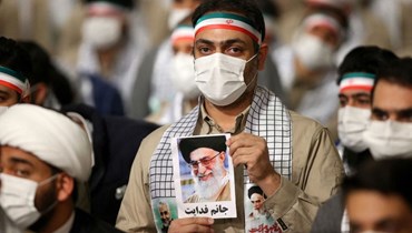 فتى إيراني يحمل صورة لخامنئي في طهران (أ ف ب).