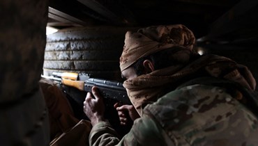 مقاتل من "الجيش الوطني السوري" المدعوم من تركيا في متراس قرب بلدة إعزاز بريف حلب على الخط الأمامي للجبهة مع بلدة منغ. (أ ف ب)