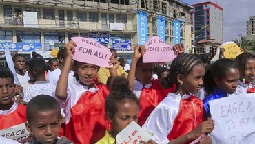 أطفال من مركز لياقة بدنية وفنون قتالية محلي يحملون لافتات سلام في كرنفال شوارع نظمته جمعية تنمية تيغراي في ميكيلي عاصمة إقليم تيغراي (26 ت2 2022، ا ب). 