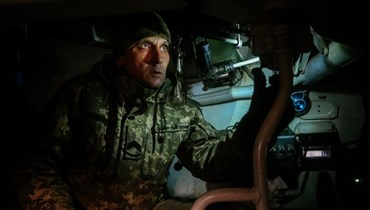 أحد رجال المدفعية الأوكرانية ينظر من خلال منظار باتجاه مواقع روسية (أ ف ب). 