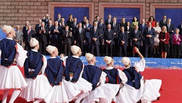 راقصون يؤدون رقصة تقليدية، بينما تجمع رؤساء دول لالتقاط صورة جماعية خلال قمة الاتحاد الأوروبي وغرب البلقان في تيرانا (6 ك1 2022، أ ف ب).