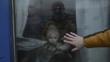 أب يضع يده على النافذة وهو يودع ابنته التي استقلت قطار الإجلاء في محطة القطار المركزية في أوديسا (7 آذار 2022، أ ف ب). 